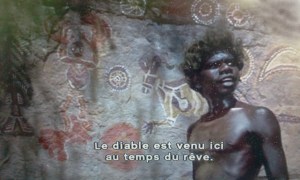 Le jeune aborigène explique sa peinture pariétale du pays du rêve